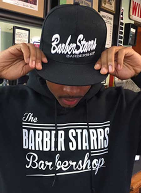 man posing with barberstarrs hoodie and hat